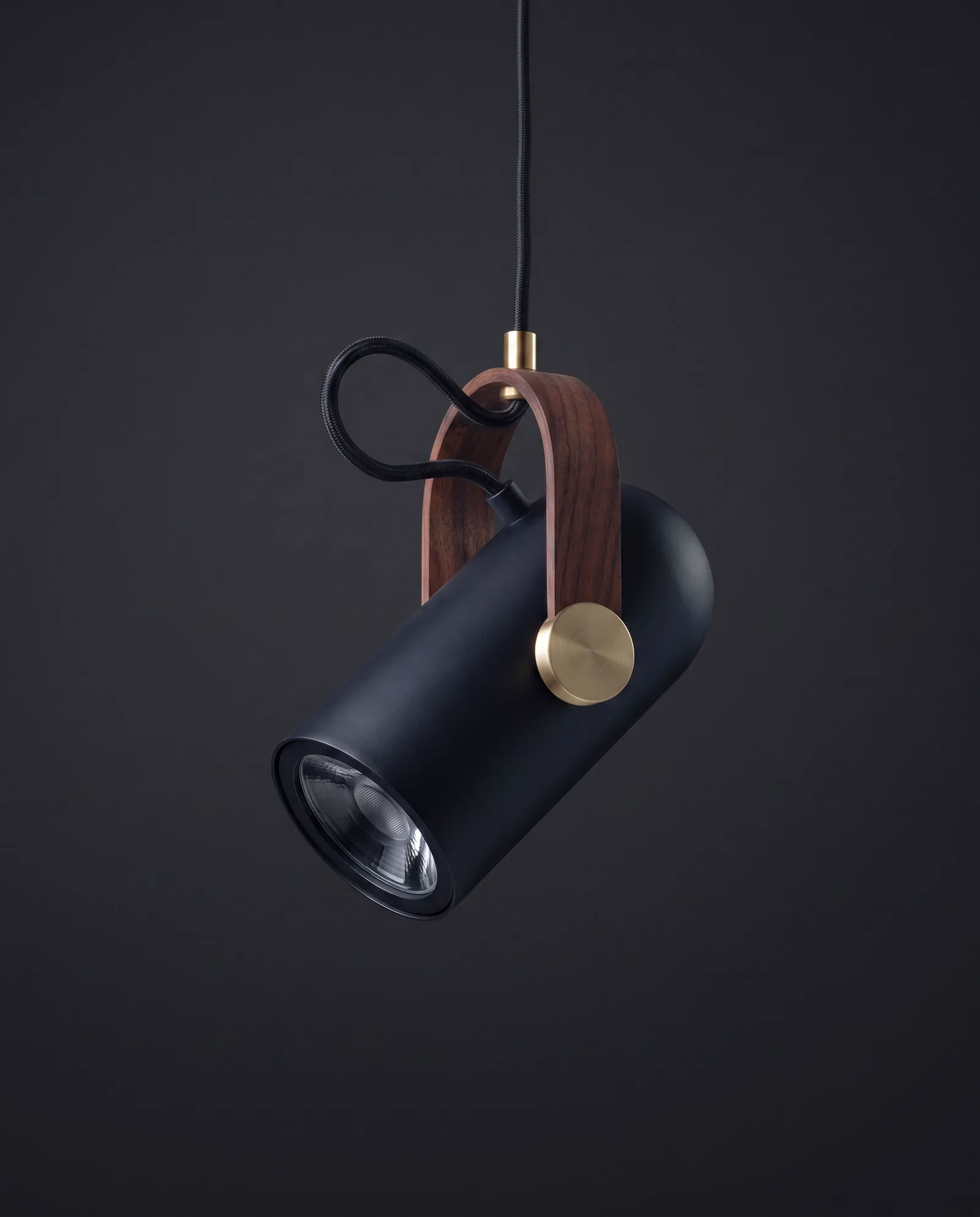 The Rotating Pendant Lamp as it arrives — matte-black cylinder, walnut strap, brass pivot